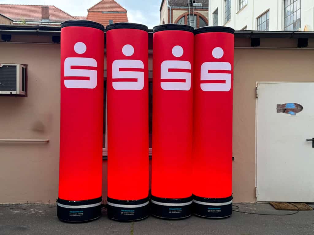 Aufblasbare Leuchtsäulen mit LED-Innenbeleuchtung und Sparkassen-Logo im Außenbereich